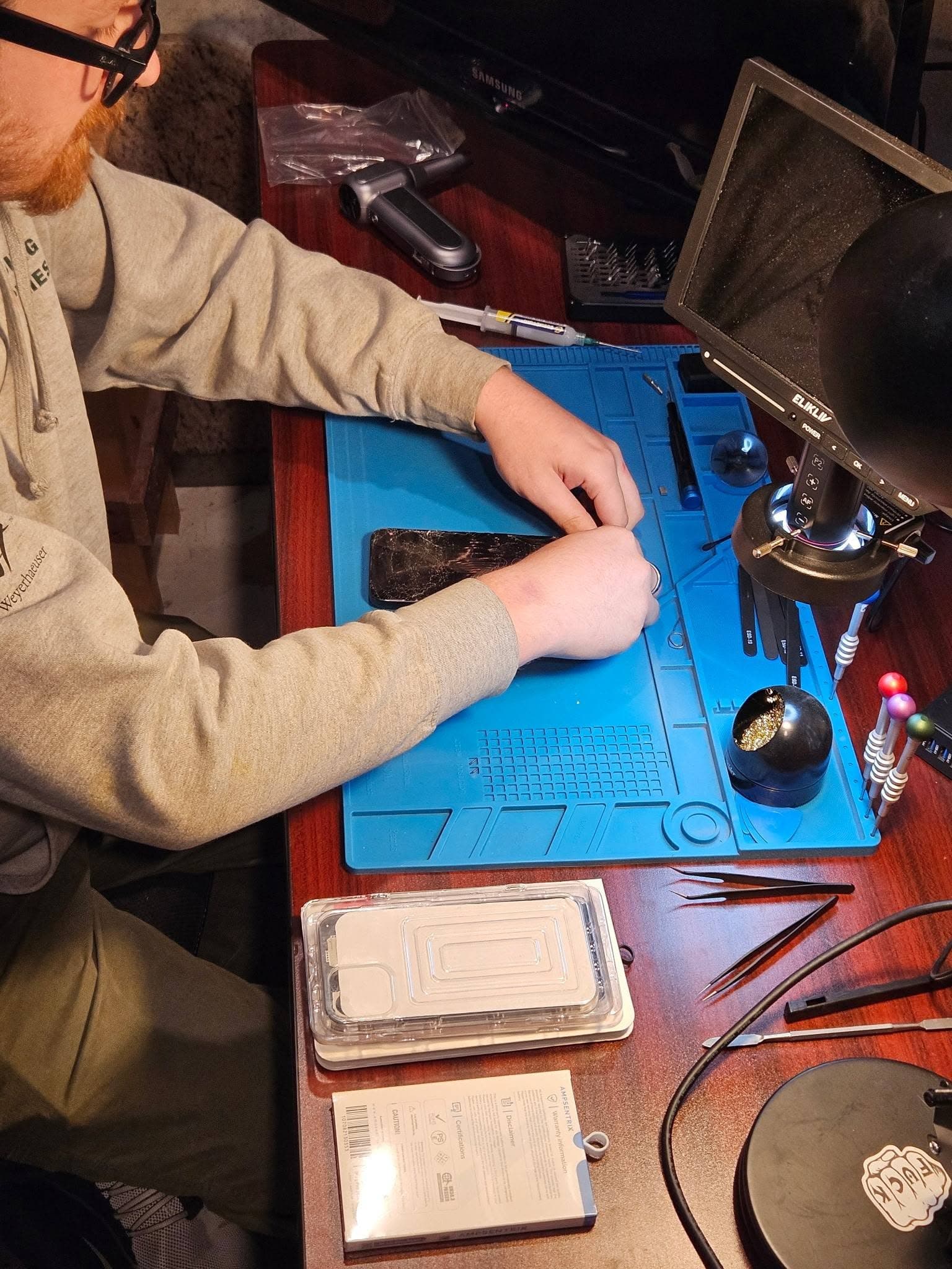 Real MPR technician repairing a phone at the workbench